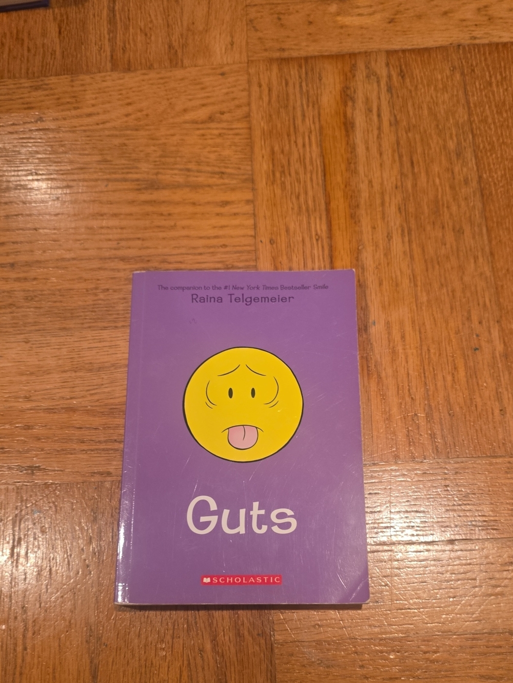 Scholastic Purple Cover Book with Yellow Emoji